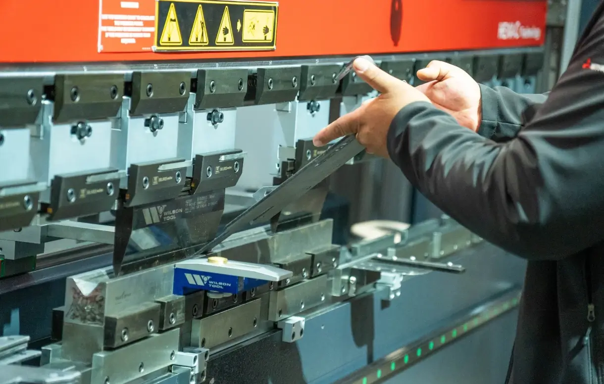 sheet metal guillotine shear Technician inspecting sheet metal guillotine shear blade and tooling assembly