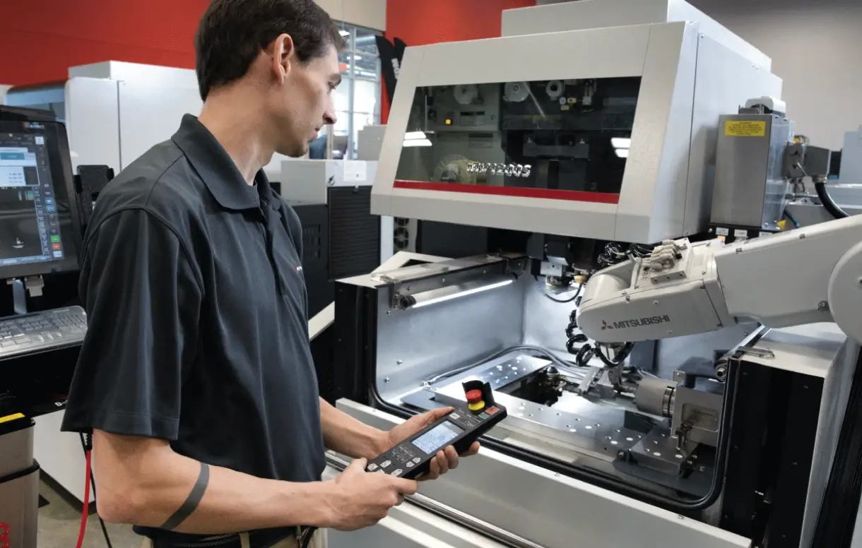 Mitsubishi wire EDM remote monitoring wire EDM machines on a clean precision shop floor with monitoring screens overhead